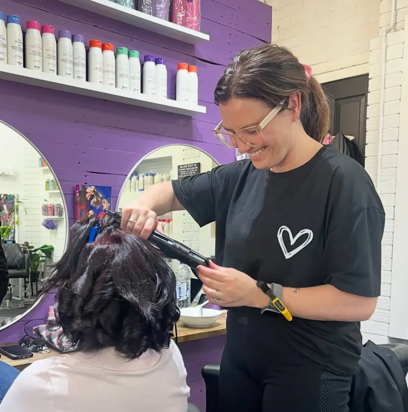 Jena styling a client’s hair inside Hair Pinns Bangor